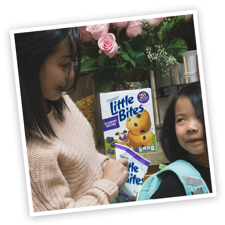 Mother and child with Little Bites Blueberry muffins package